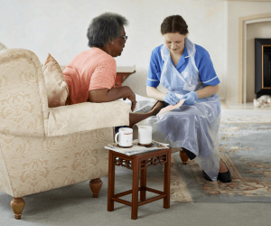 Caregiver helping elderly patient to recover