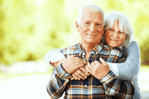 An elderly couple hugging each other