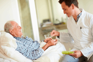 Caregiver distributing medicine for an elderly patient